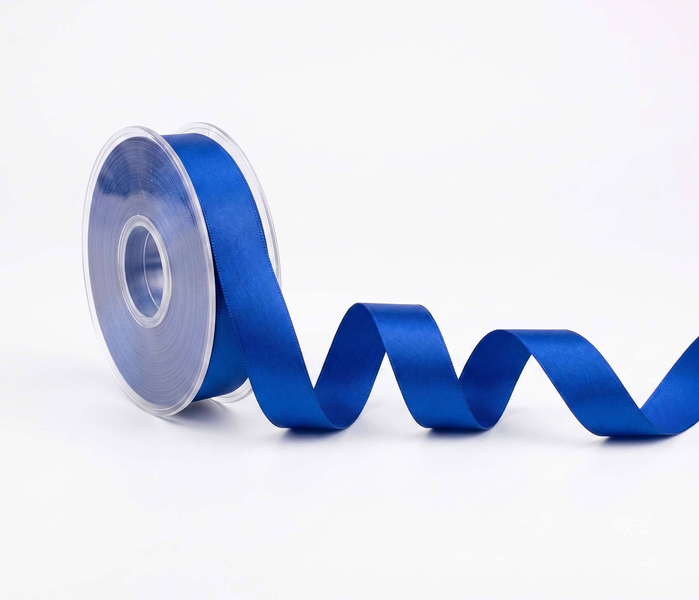 A roll of vibrant royal blue satin ribbon with a glossy finish, partially unrolled in a wavy line on a clean white background.