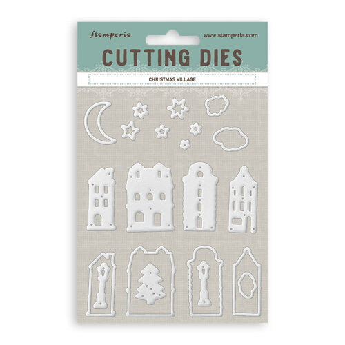 A package of Stamperia Christmas Village cutting dies, featuring white metal die-cut shapes including houses, stars, clouds, and a crescent moon on a textured beige backing card with a teal header.