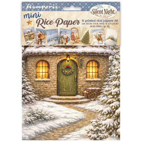 A package of Stamperra mini Rice Paper 'Silent Night' A6 cardstock. The packaging features a festive illustration of a stone cottage with a green door, glowing yellow windows, and a wreath, surrounded by snow-covered trees and a pathway.