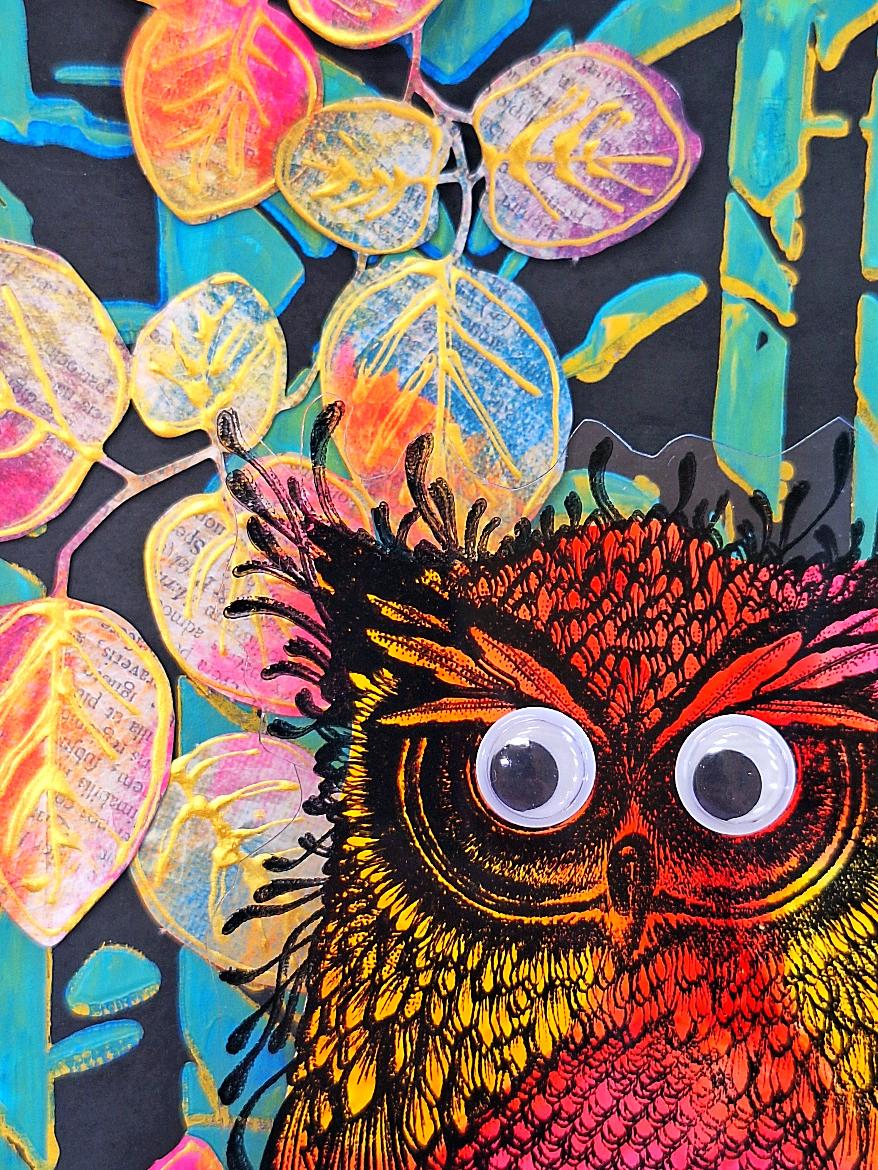 A close-up of a colorful owl illustration or art print, showing a red, orange, and yellow owl with large white eyes against a dark background with stylized leaves in pink, yellow, and blue.
