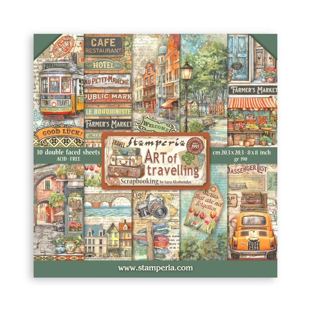 A collection of double-sided scrapbooking paper sheets with various travel-themed designs, including old-world cityscapes and transportation-related imagery.