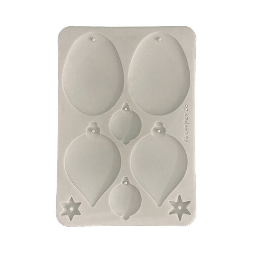 A rectangular silicone mold with six Christmas ornament-shaped cavities, including teardrop, round bauble, and star designs, shown on a plain white background.