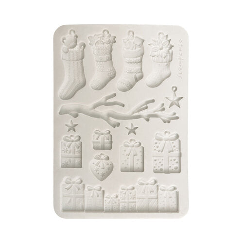 A rectangular white silicone baking or craft mold with embossed Christmas-themed designs including stockings, gifts, stars, and a branch, shown on a plain white background.