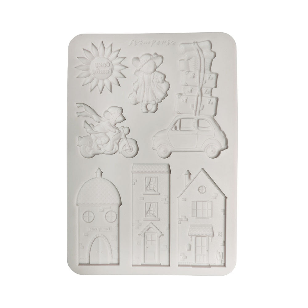 A white rectangular silicone mold with multiple embossed designs, including houses, a scooter, a sun, a child, a car, and stacked boxes, on a plain white background.